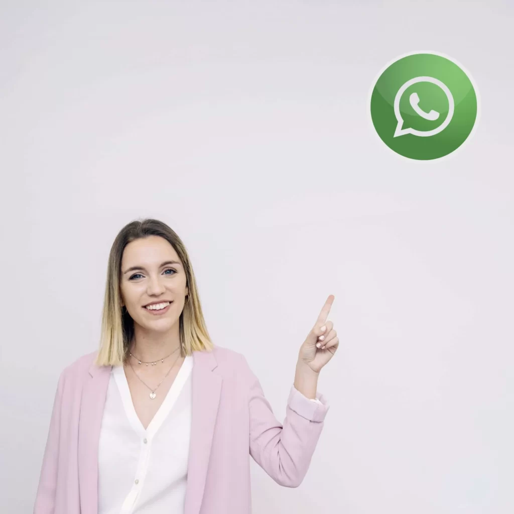 beautiful young woman standing against white background pointing at whatsup icon scaled 1 Homlity Herramienta para Inmobiliarias